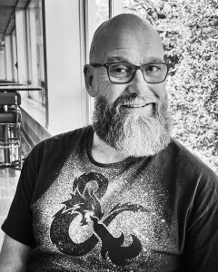Dr. Jeffrey MacLeod, in a greyscale photo wearing a Dungeons and Dragons Shirt