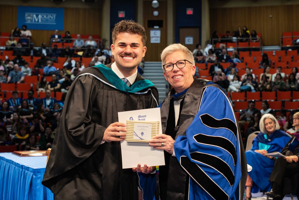 Tourism and Hospitality Management student on stage with president at the May 2026 graduation ceremony. Both look very happy.