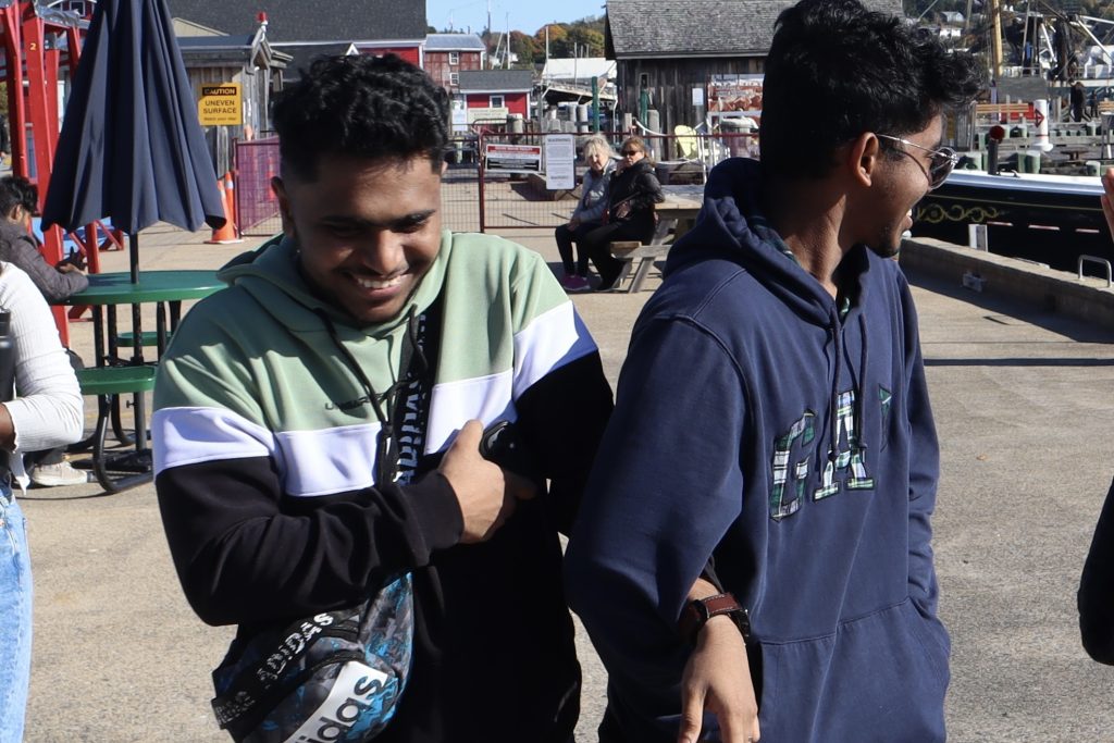 Two male Mount business and tourism student laughing whilst walking in downtown Lunenburg NS on a beautiful sunny day during the 2024 sustainable business tour. 