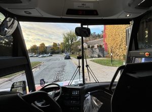 This is photo is the view out the front window of a bus. 