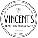 This is the MSVU Tourism and Hospitality Vincent's teaching restaurant logo. It is black text on a white background. The logo is circular. At the top it says Tourism & Hospitality Program. Under this is a spoon, a fork and a knife. Under this in big letters is the word Vincent's and under that it says Teaching Restaurant, followed by two lines and under the lines it says est 1987.
