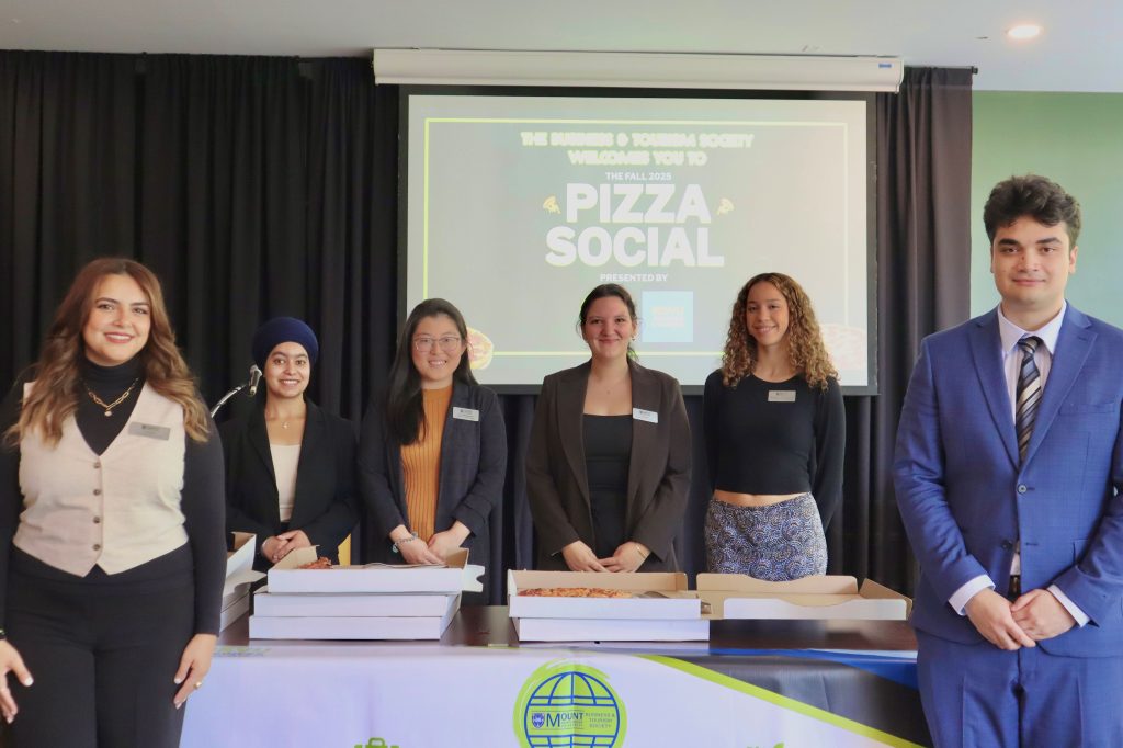 Mount Saint Vincent University 2026 Business and Tourism Society Executive team. Standing at the front of the room  at the Rook during their pizza social. 