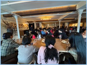 MSVU business and tourism students in Pazzo Ristorante, sitting at tables listening to the presentation about how to run a successful business during the 2026 local entrepreneur and cultural tourism tour. 