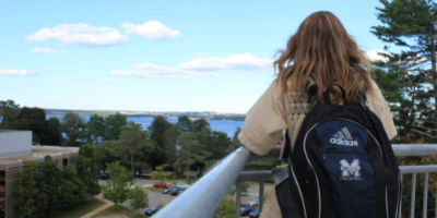 A student looking at the MSVU campus with the text Mount 101 in the background