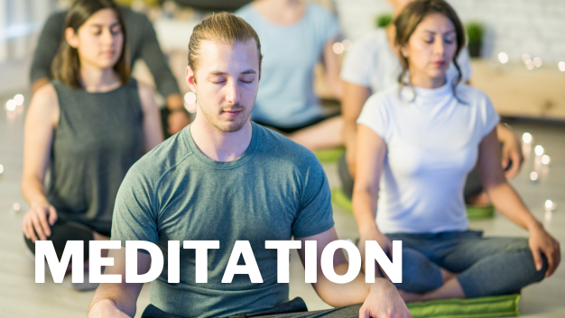People sit cross‑legged on yoga mats with eyes closed in an indoor studio, with large text reading “MEDITATION.”