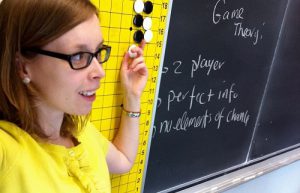 Dr Danielle Cox in front of a blackboard