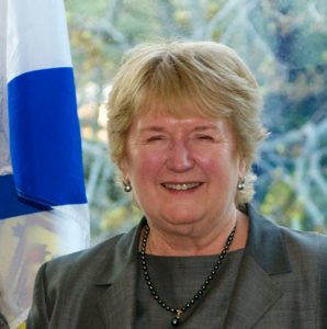Rosemarie Sampson posing in front of the Nova Scotia flag