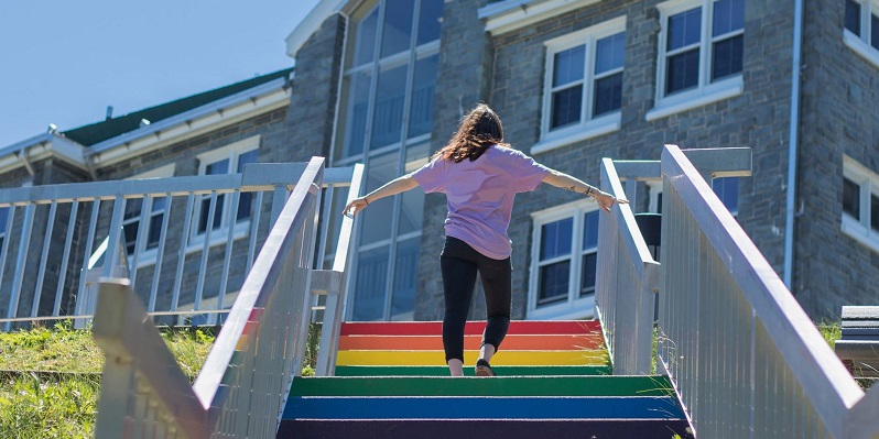 Student walking up the pride staircase up to Evaristus