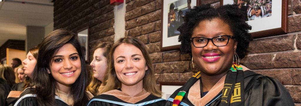  Happy Business and Tourism graduates in the hallway of Seton Academic Centre waiting to go in to their graduation ceremony. May 2017.