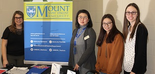 Faculty and students standing at a booth during open campus day Fall 2017