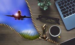 Image of airplane, laptop, coffee, reading glasses