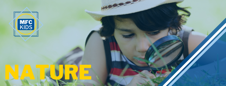 child with a magnifying glass looking at the ground