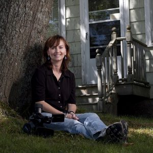 Dr. Meredith Ralston sitting outside with a video camera beside her