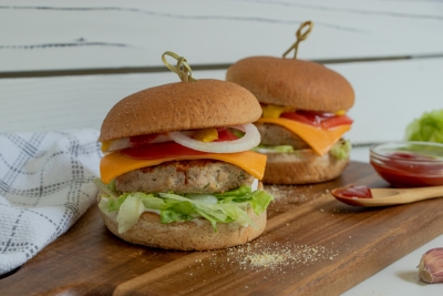Two turkey burgers on a wooden serving board