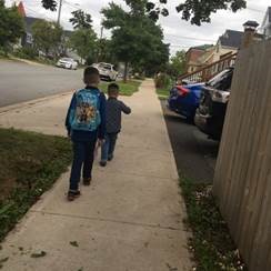 Two children walking down the street