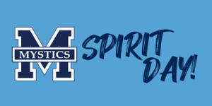 A blue background with a large letter 'M' in white and navy blue on the left side. Inside the 'M' is a navy blue rectangle with the word 'Mystics' in white capital letters. To the right of the 'M,' there are the words 'Spirit Day!' written in a bold, brushstroke-style font in navy blue.
