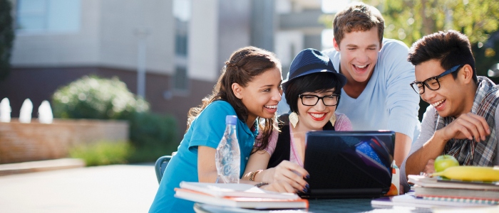 Students gathered around a laptop