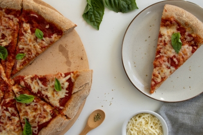 Whole wheat cheese pizza and slice of pizza on a plate