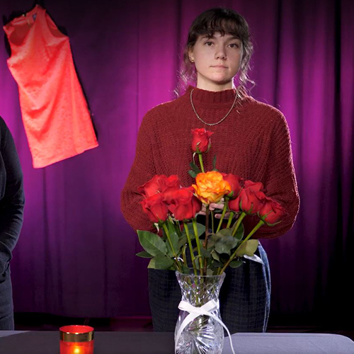 A student placing a rose in memory of the women who were killed at Ecole Polytechnique 32 years ago