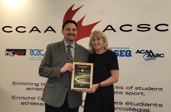 June Lumsden pictured at right, receiving her Athletics Director of the Year Award from CCAA President, Vince Amato