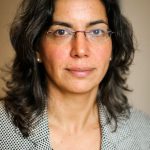 Photograph of Maya Eichler shows a woman with dark shoulder-length hair and glasses. She is looking directly at the camera with a kind expression. 