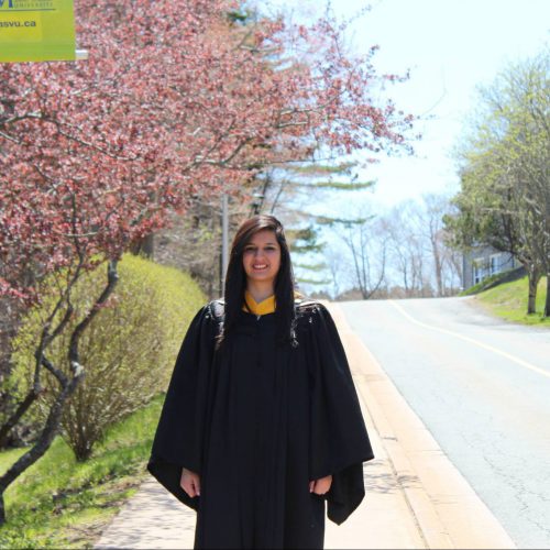 Alissa Ali posing for a picture on the sidewalk near Evaristus Hall