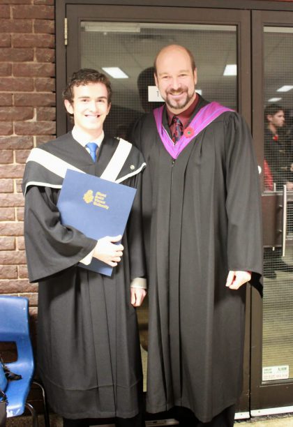 Sean Joudry posing for a photo at convocation with their degree