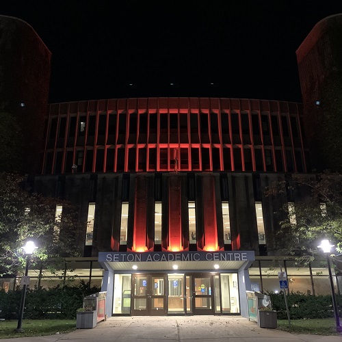 Seton Academic Centre lit up with orange lights at light
