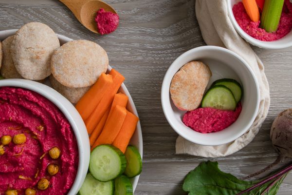 Platter with roasted beet hummus, vegetables, and mini pita