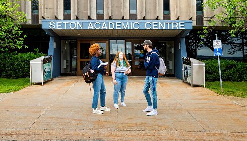 Three students standing in front of Seton Academic Centre