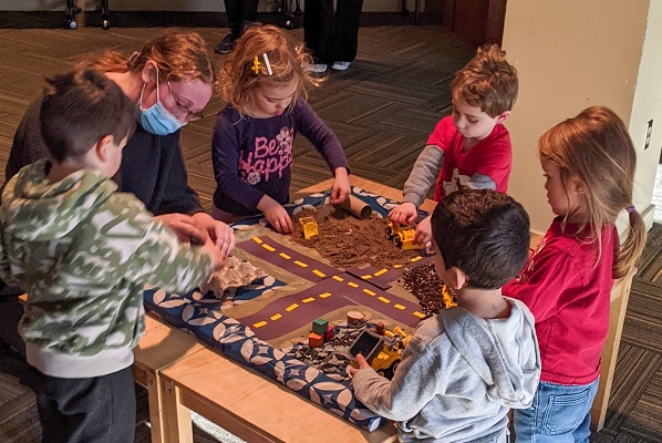 A CHYS Student playing with 5 children from the Child Study Centre