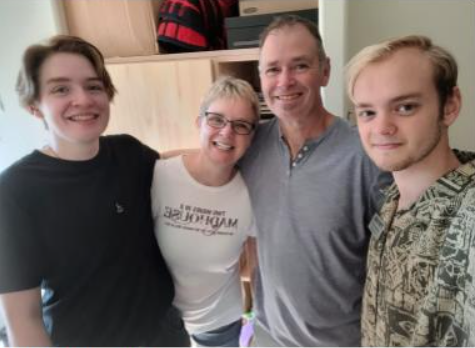 Michael Gillis posing with his family in his dorm room