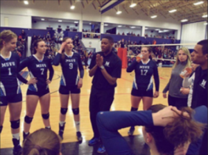 Tyler Simmons speaking to the Women's Volleyball team during a game
