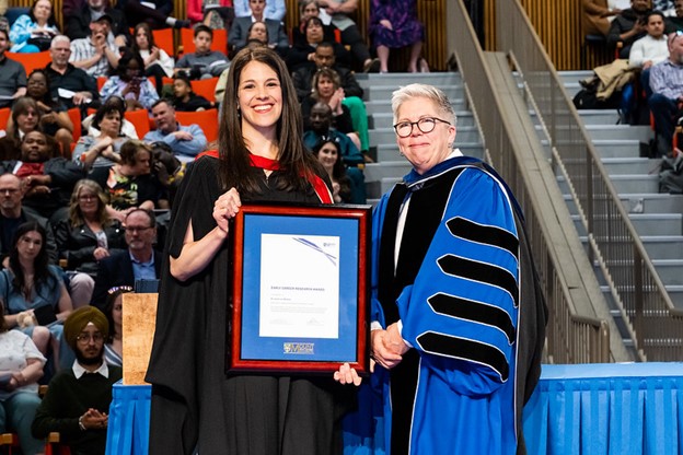 Dr. Jessie-Lee McIsaac and Joël Dickinson holding the Early Career Research Award at Convocation
