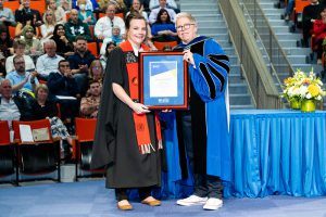 Lindsay Leighton, standing with Dr. Joël Dickinson receiving their award