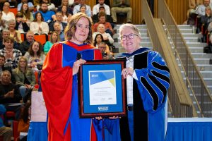 Dr. Michelle Eskritt, standing with Dr. Joël Dickinson receiving their award