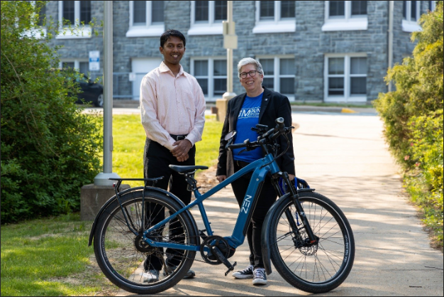 Ravindra Kempaiah and Dr. Joël Dikcinson posing beside a Zen Electric Bike