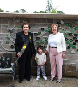 Lena Metlege Diab standing beside her leaf at the Women's Wall of Honour
