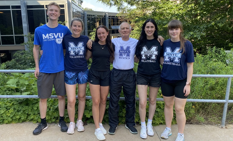 John Carnaghan standing outside Rosaria with some students