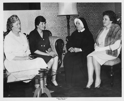 Marie Jones sitting with various alumnae association members and the MSVC president