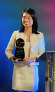 Christine Yang holding the 2023 International Alumni of Impact award