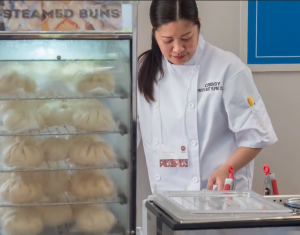 One of the SPICE participants standing beside Steamed Buns