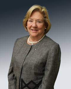 The Honourable Margaret Norrie McCain in a grey outfit standing in front of a greyscale background