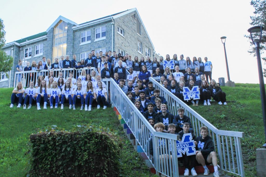 The various MSVY Mystics sports teams and coaching staff seated outside of Evaristus hall