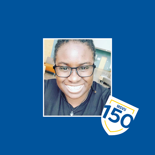 Kamla Williams smiling in the McCain Atrium. The photo is surrounded by a blue background and the MSVU 150 logo is beside the photo.