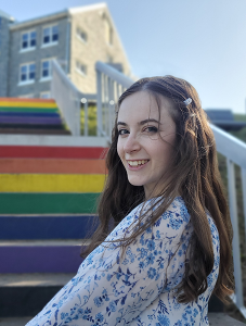 Cheyenne Hardy posing beside the Pride Stairs near Evaristus Hall