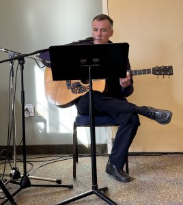Dr. James Sawler playing guitar for a performance at be the National Day of Remembrance and Action on Violence Against Women vigil.