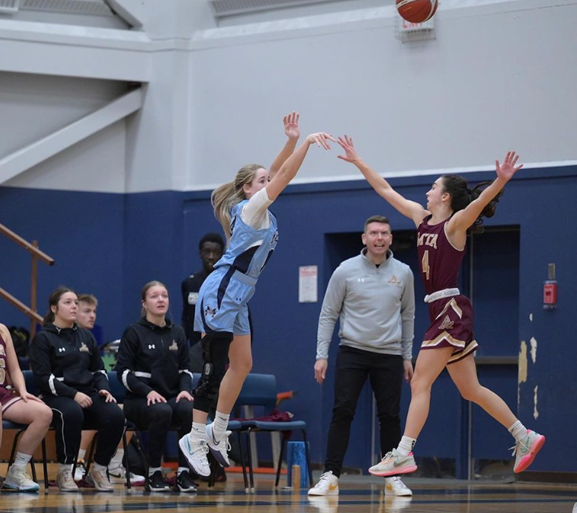 Two basketball players, one from MSVU and one from Mount Allison, in a basketball game