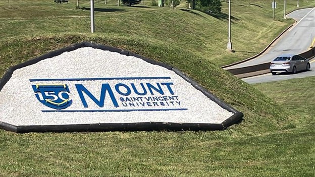 the 150th MSVU logo on the grassy bank heading onto the McKay Bridge (Dartmouth bound).