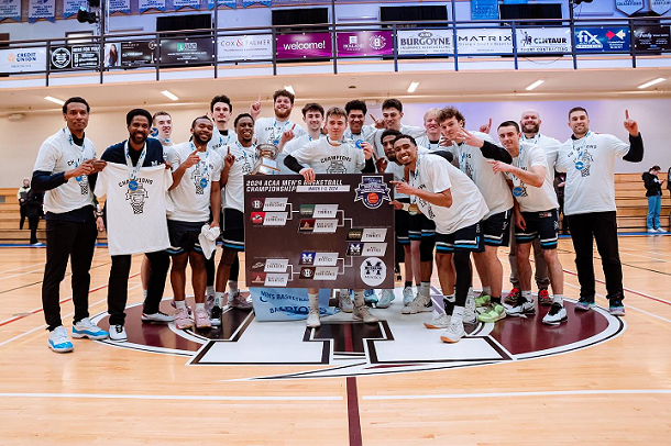 The MSVU Men's basketball team holding the ACAA championship banner